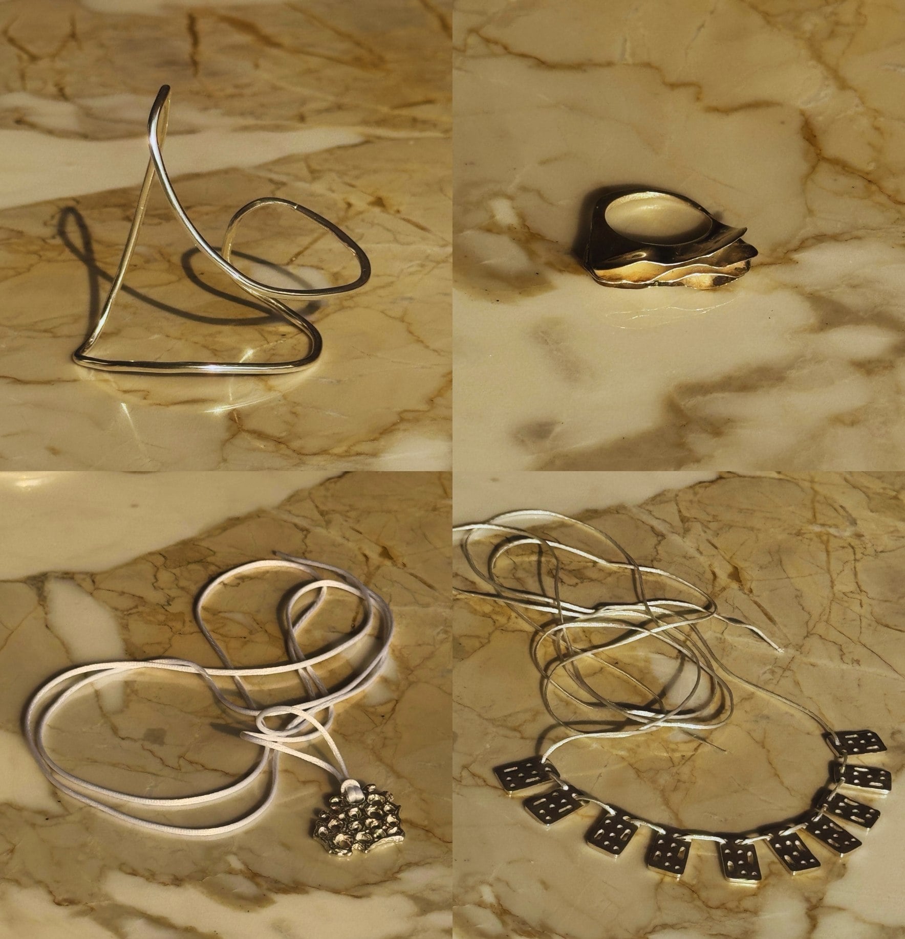 Cuatro piezas de joyería en plata de Archivo .925 fotografiadas sobre mármol: un brazalete escultórico, un anillo, un collar con dije y un collar de placas.
